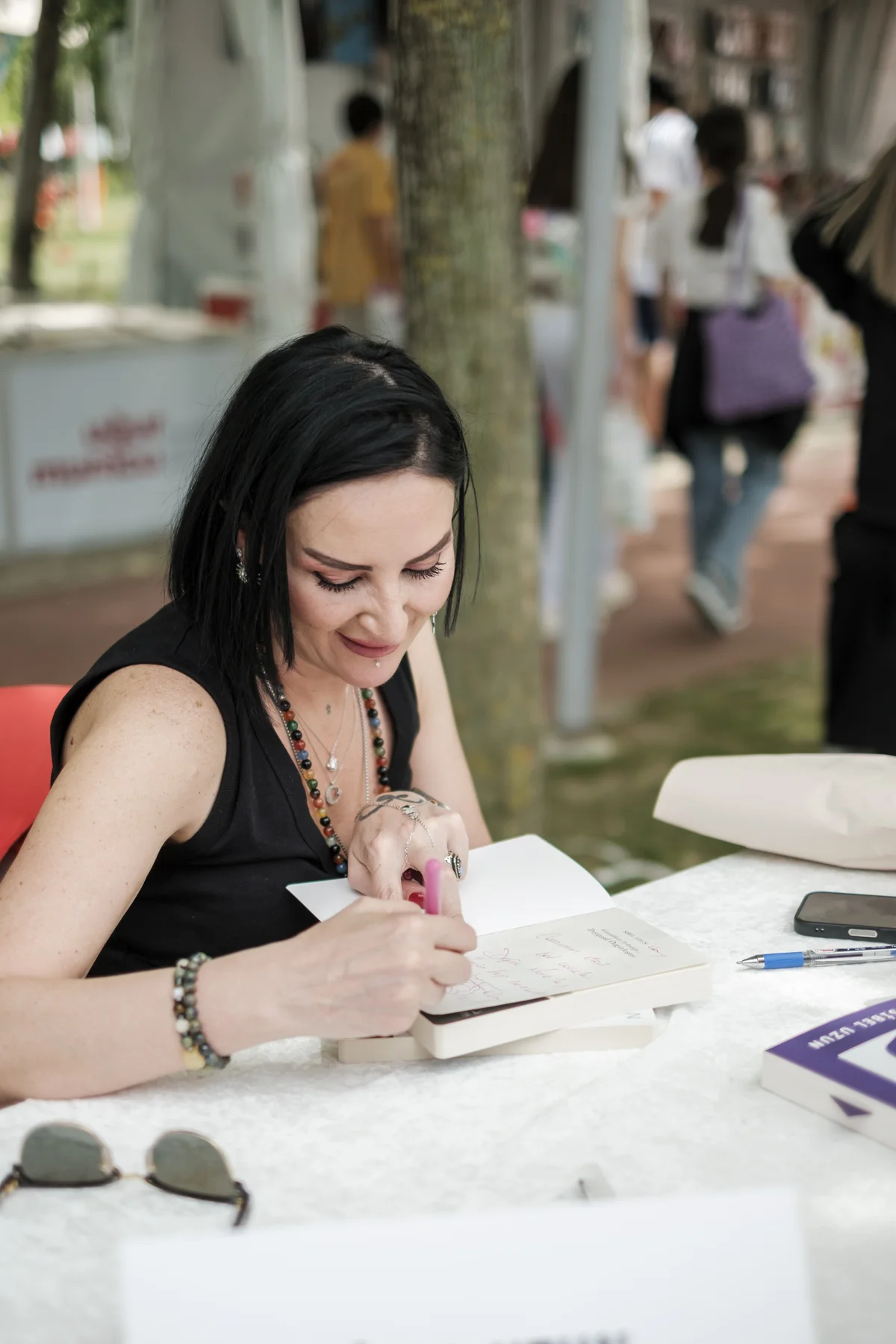 Bir yazarın masada kitap imzalaması